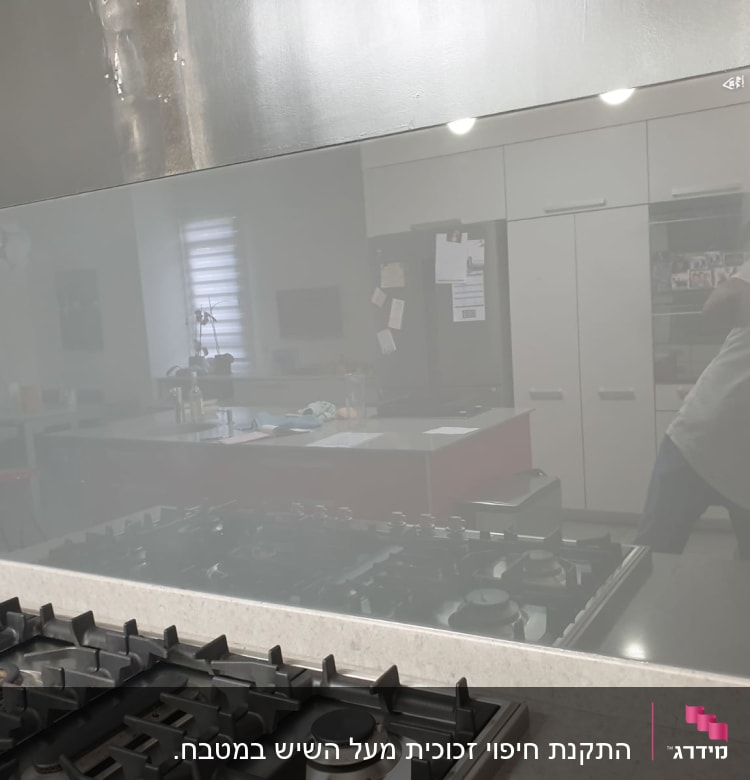 זכוכית מחזירה השתקפות של מטבח מודרני